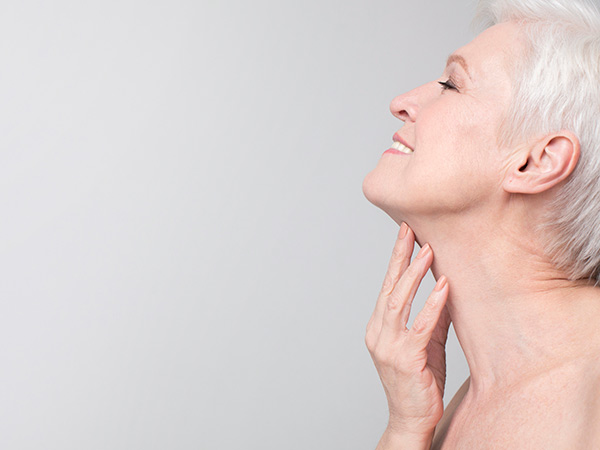 old woman touching neck