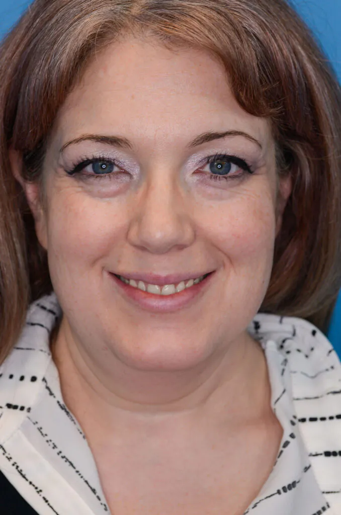 A woman smiles directly at the camera.